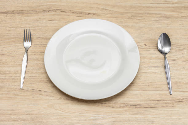 istock Close up setting of White plate on the wooden table. 1074077078