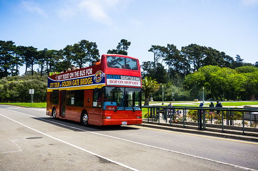 July 20, 2018 San Francisco / CA / USA - Hop on Hop off Double Decker city tour bus taking tourists through Golden Gate Park