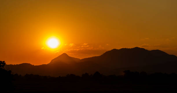 istock Sunset over silhouette mountain and rice field in evening 1074078678