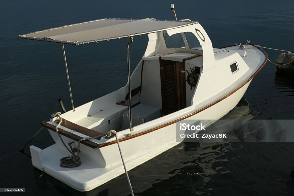 Small White Motor Fishing Boat With Wooden Helm Simple Small Cabin In Front  And Rain Protective Canopy On Back Stock Photo - Download Image Now - iStock