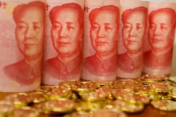 Yuan notes from China's currency. Chinese banknotes. Chinese coins.The concept of wealth fund savings and financing.The head of Chinese leader Mao Zedong.