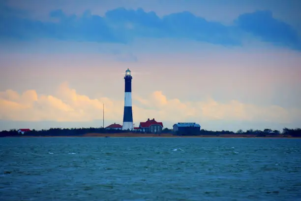 Photo of Fire Island Lighthouse with beaming light on Long Island Sound, New York