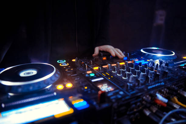 istock DJ turntable console mixer controlling with two hand in concert nightclub stage. 1074090174