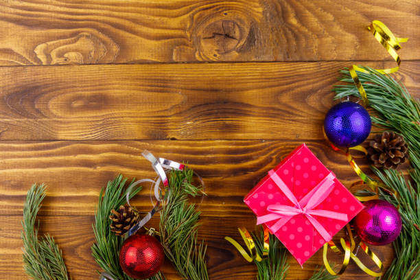 istock Christmas composition with fir tree branches, gift box and Christmas decorations on wooden table. Top view, copy space 1074092188