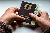 Woman's hand holding russian pension certificate.
