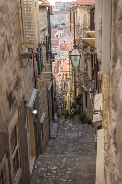Narrow medieval alley with downstairs view in Dubrovnik, Croatia Narrow medieval alley with downstairs view in Dubrovnik in winter, Croatia dubrovnik walls stock pictures, royalty-free photos & images