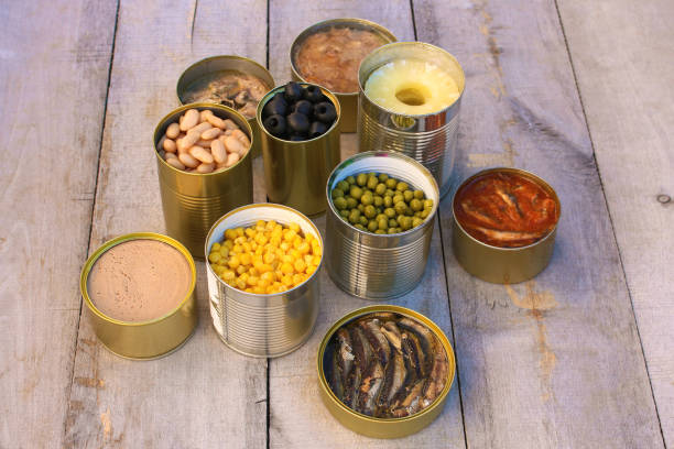 istock Different open canned food on old wooden background. 1074110144