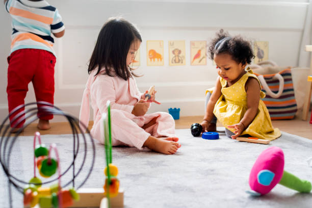 kleine kinder spielen spielzeug im kinderzimmer - little girls african descent black small stock-fotos und bilder