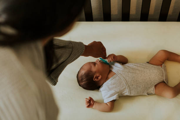 madre che si cura di un bambino addormentato - childrens music foto e immagini stock