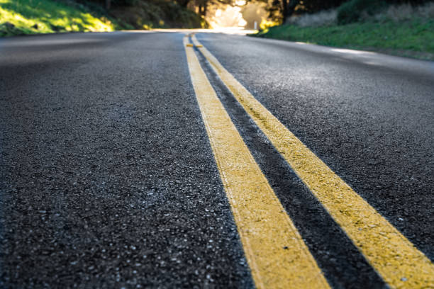 Rural road: Close-up of asphalt road with double yellow line at low angle Rural road: Close-up of asphalt road with double yellow line at low angle mendocino photos stock pictures, royalty-free photos & images