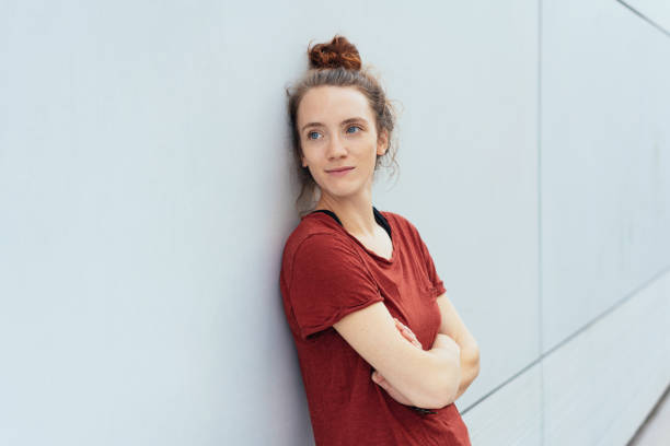 istock Thoughtful young woman leaning against a wall 1074145600
