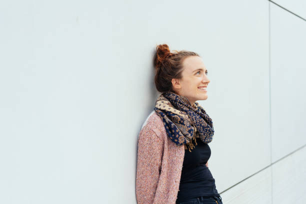 istock Smiling young woman leaning against building 1074145954