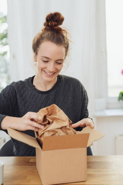 istock Excited young woman unwrapping a gift 1074146212