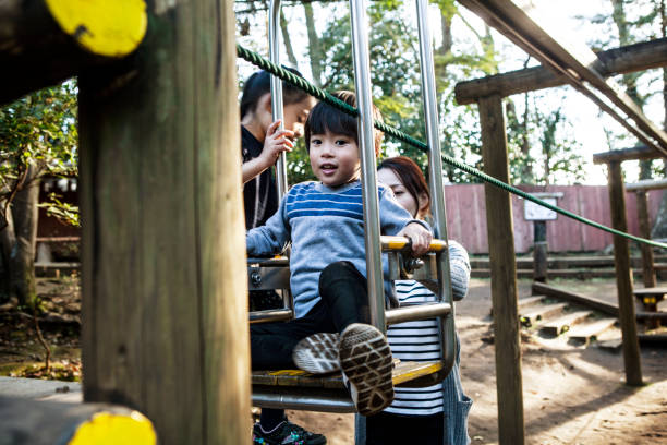 istock Family who is playing with ropeway type playground equipment. 1074146306
