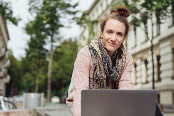 istock Woman typing on laptop while looking at camera 1074148412