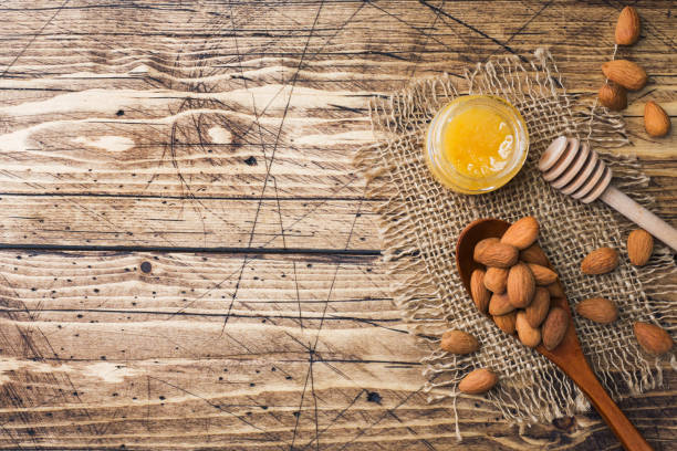 Almonds and a can of honey on the table. Selective focus. Copy space.