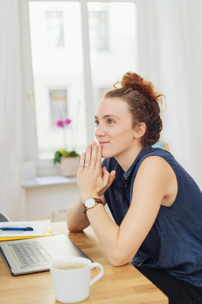 istock Young businesswoman sitting with clasped hands 1074151020