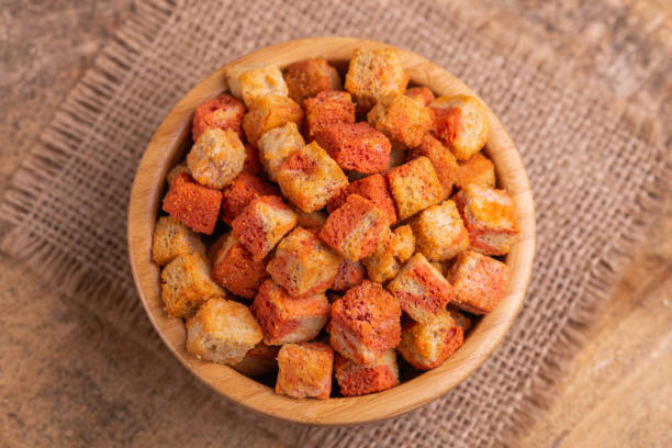istock Bacon flavored crackers in wooden bowl on burlap napkin. Beer appetizer 1074155302