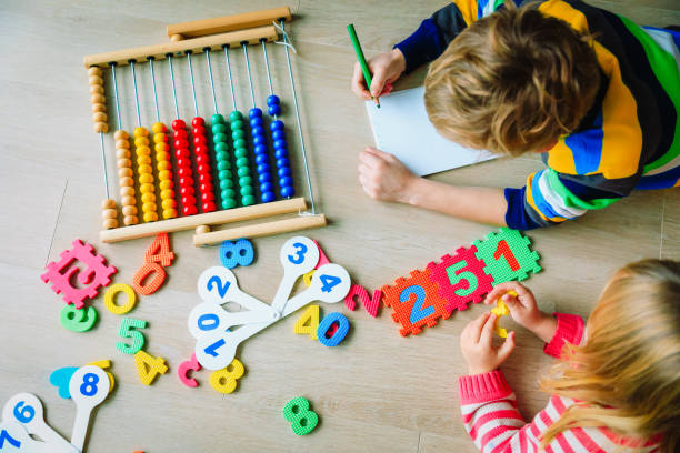 istock little boy and girl learn to write and calculate numbers 1074155402