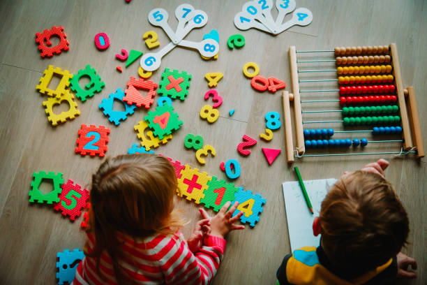 istock little boy and girl learn to write and calculate numbers 1074157764