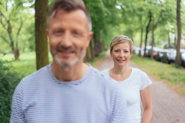 istock Middle-aged couple walking along a country road 1074160714