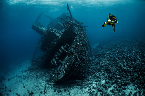 istock Scuba diver passing by an underwater shipwreck in the Red Sea 1074164368