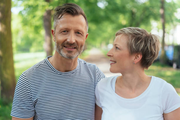 istock Mature man walking through a park with his wife 1074166082