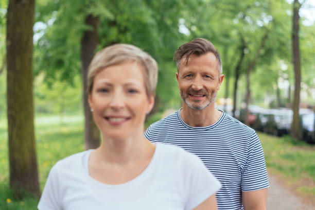 istock Mature couple enjoying a walk through a park 1074166428
