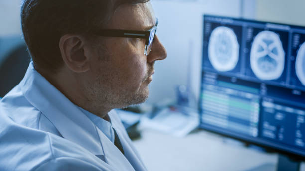 클로즈업 초상화 전문 의사의 뇌 종양 이나 암, 질병을 진단 하는 것을 시도의 흔적을 찾고, 그의 컴퓨터 모니터에 mri 또는 ct 이미지를 보고. - radiologist x ray computer medical scan 뉴스 사진 이미지