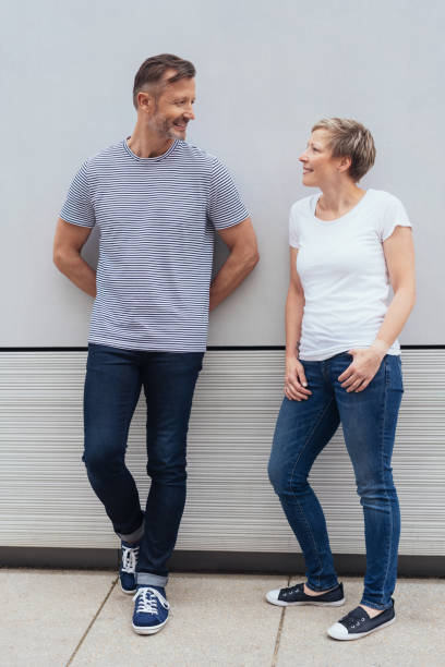 istock Mature couple leaning on a wall chatting 1074167362
