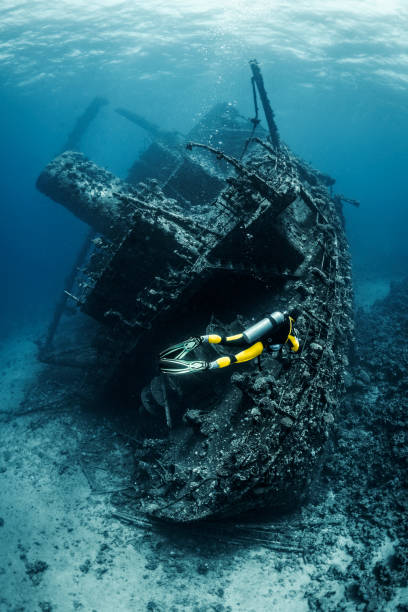 istock Scuba diver observing a large shipwreck completely rusted and overgrown lying underwater in the Red Sea 1074169154