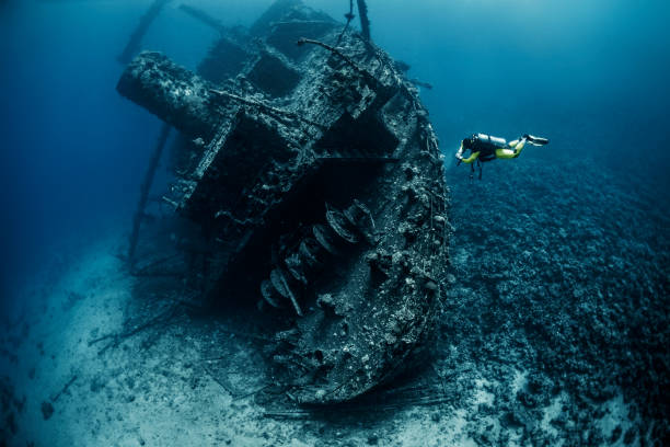istock Scuba diver observing a large shipwreck completely rusted and overgrown lying underwater in the Red Sea 1074169492