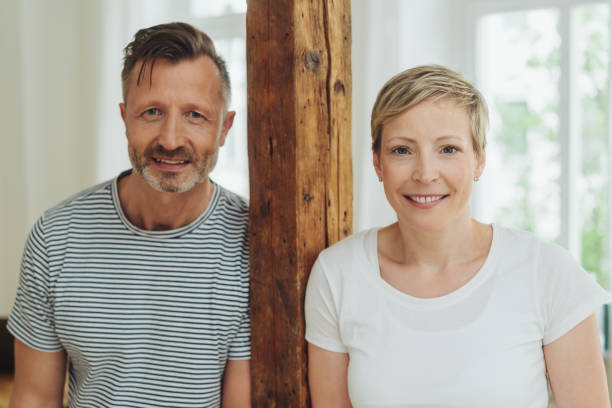 istock Middle-aged couple leaning on a wooden column 1074173418