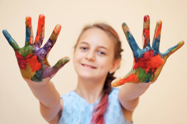 istock Little girl with palms in paints 1074174048
