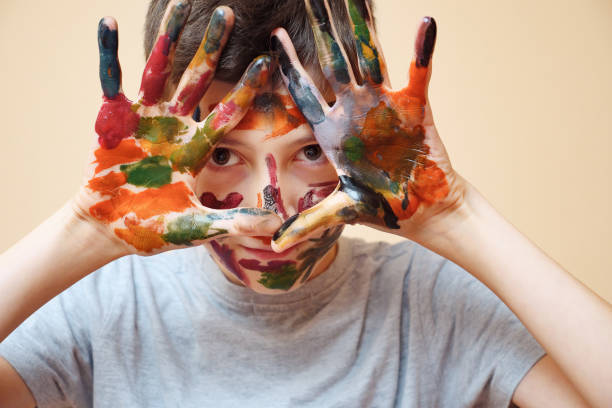 istock Closeup of boy with face and hands in paint 1074174064