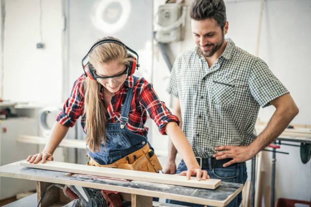 istock Young female crafter grinding wood plank at the carpenter workshop 1074175894