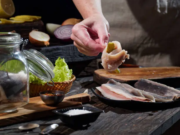 Preparing homemade rollmops, traditional European herring snack