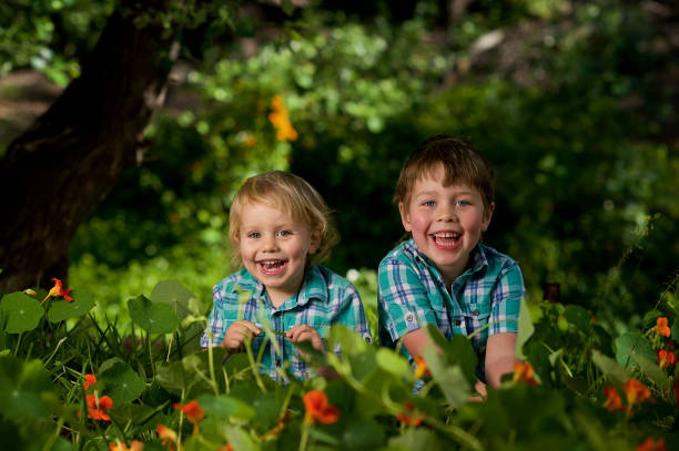 istock Two brothers laughing together in the nastrurtiums 1074179512