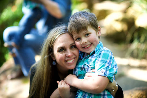 istock Mother and son embrace looking at camera 1074181932