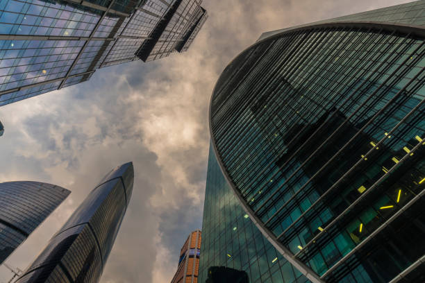 istock bottom-up view of skyscrapers and flying clouds 1074182062