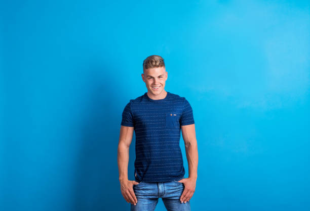Portrait of a cheerful young man in a studio standing in a studio.