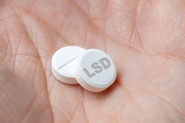 Two white LSD pills drugs in hand. closeup Two white LSD pills drugs in hand. closeup acid stock pictures, royalty-free photos & images