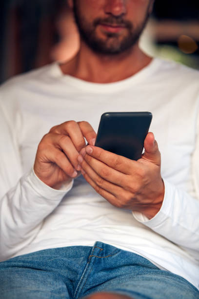 istock Man sitting on a terrace sofa and using cellphone. 1074195138