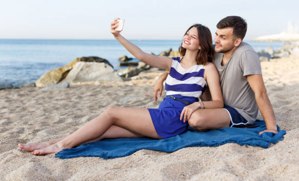 istock Young loving couple resting and taking selfie 1074199058