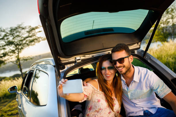 istock Young smiling couple on road trip taking Selfie 1074200974