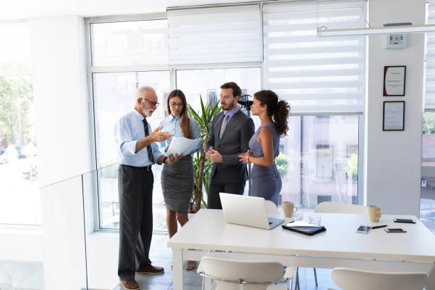 istock Senior businessman sharing some data with colleagues 1074206416