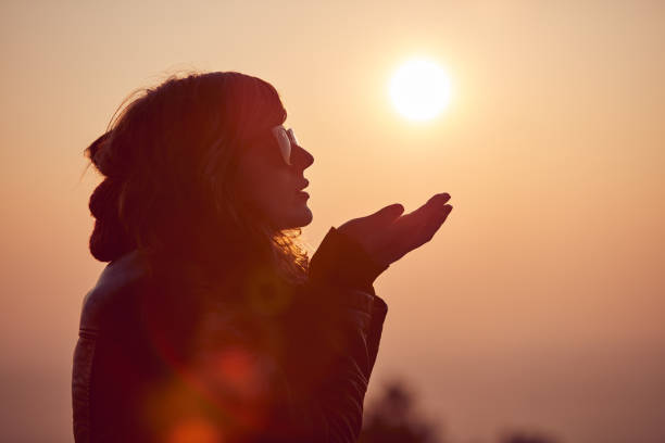 istock Woman with praying arms enjoying the sunrise / sunset time. 1074209708