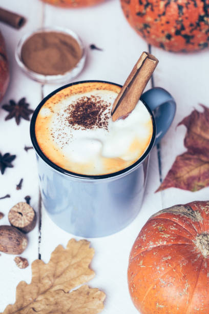 istock Pumpkin spice latte or coffee with cinnamon and nutmeg. Autumn, fall or winter hot drink. Old white wooden background with yellow leaves and pumpkins 1074213048