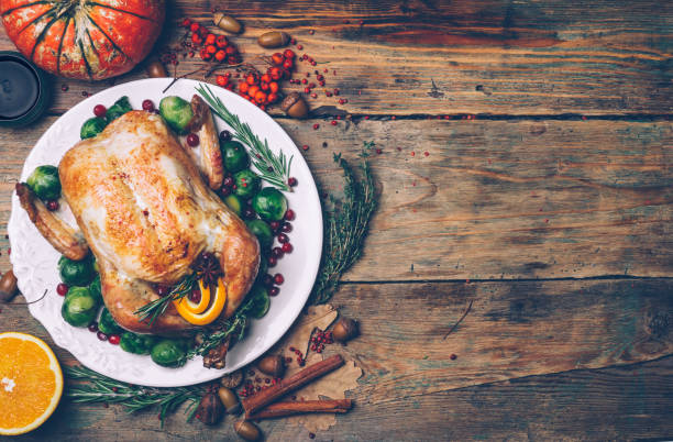 istock Thanksgiving roasted chicken with Brussels sprouts and spices on a rustic wooden table. Thanksgiving dinner or fall dinner concept background with autumn leaves. Thanksgiving table setting background. 1074213252