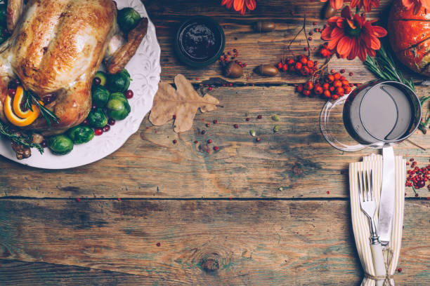 istock Thanksgiving roasted chicken with Brussels sprouts and spices on a rustic wooden table. Thanksgiving dinner or fall dinner concept background with autumn leaves. Thanksgiving table setting background. 1074213264